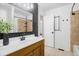 Well-lit bathroom with a single sink vanity, dark accent wall, a large mirror, and a shower and tub combination at 6318 Newton Ct, Arvada, CO 80003