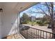 A balcony overlooking a parking lot, trees, and surrounding buildings, offers a serene outdoor retreat at 13093 W Cedar Dr # 322, Lakewood, CO 80228