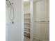 Clean bathroom with tiled shower and open shelving at 13093 W Cedar Dr # 322, Lakewood, CO 80228
