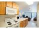 Functional kitchen with wooden cabinets and modern appliances, and a view of living room at 13093 W Cedar Dr # 322, Lakewood, CO 80228