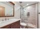 Bathroom featuring wood vanity and stylish tile in the glass enclosed shower at 13322 Marion St, Thornton, CO 80241