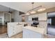 Updated kitchen featuring white cabinets, stainless steel appliances, a mosaic backsplash, and center island at 13322 Marion St, Thornton, CO 80241