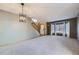 Spacious living room with new carpet, a stairway, large windows with natural light, and stylish lighting at 13322 Marion St, Thornton, CO 80241