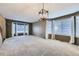 Bright and airy living room with new carpet, large windows, new curtains, and stylish light fixture at 13322 Marion St, Thornton, CO 80241