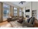 Bright, virtually staged living room featuring high ceilings, large windows, fireplace, and built-in shelving at 13322 Marion St, Thornton, CO 80241