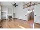 Spacious living room featuring hardwood floors, fireplace, built-in shelving, and a view to the upstairs landing at 13322 Marion St, Thornton, CO 80241