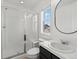 Bright bathroom with a glass shower, white tile, and a black framed mirror at 10730 Hillrose St, Parker, CO 80134