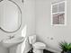 Modern half bathroom with a pedestal sink, toilet, and window at 10730 Hillrose St, Parker, CO 80134