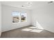 Bright bedroom featuring light gray carpet, white walls, and sunlit windows at 10730 Hillrose St, Parker, CO 80134
