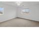 Light-filled bedroom with gray carpet, white walls, and exterior views at 10730 Hillrose St, Parker, CO 80134