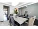 Bright dining room featuring a modern chandelier, stylish gray chairs around a large table and sleek, dark wood floors at 10730 Hillrose St, Parker, CO 80134