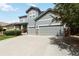 Charming two-story home with a well-manicured lawn, two-car garage and appealing gray siding with stone accents at 10730 Hillrose St, Parker, CO 80134