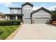 Charming two-story home with a well-manicured lawn, two-car garage and appealing gray siding with stone accents at 10730 Hillrose St, Parker, CO 80134