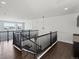 Open hallway features hardwood floors, black metal railings and hanging light fixture at 10730 Hillrose St, Parker, CO 80134