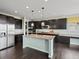 A spacious kitchen with dark wood cabinets, stainless steel appliances, and a central island with granite countertops at 10730 Hillrose St, Parker, CO 80134