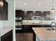Modern kitchen featuring granite countertops, dark cabinets, and stainless steel appliances at 10730 Hillrose St, Parker, CO 80134