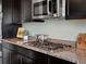 Close up of modern gas range with granite countertop and stainless steel microwave at 10730 Hillrose St, Parker, CO 80134