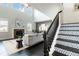 Open-concept living room with soaring ceilings, a fireplace, and a staircase with decorative patterned treads at 10730 Hillrose St, Parker, CO 80134