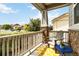 Inviting front porch featuring stone columns, a cozy chair, and a charming yellow and white patterned rug at 10730 Hillrose St, Parker, CO 80134