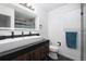 Modern bathroom with a long countertop, dual faucets, large mirror and a walk-in shower at 4485 E Andover Ave, Castle Rock, CO 80104