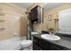 Bathroom with a shower-tub, dark wood cabinet, and an oval sink at 6267 N Dunkirk Ct, Aurora, CO 80019