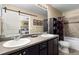 Bathroom features double sinks, dark wood cabinets, and a shower-tub with dark accents at 6267 N Dunkirk Ct, Aurora, CO 80019