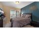 Bedroom with a large window, dark furnishings, neutral carpet and a blue accent wall at 6267 N Dunkirk Ct, Aurora, CO 80019