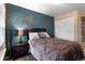 Bedroom showcasing an accent wall, side table with lamp, closet, and wall decor at 6267 N Dunkirk Ct, Aurora, CO 80019