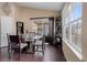 Well-lit dining area with a modern glass table, hardwood floors, and a large sliding glass door at 6267 N Dunkirk Ct, Aurora, CO 80019