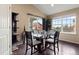 Bright dining area with a modern glass table, hardwood floors, and sliding glass doors to the patio at 6267 N Dunkirk Ct, Aurora, CO 80019