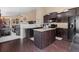 Stylish kitchen with an island, dark wood cabinets, granite countertops, and stainless steel appliances at 6267 N Dunkirk Ct, Aurora, CO 80019