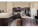 Modern kitchen boasts dark wood cabinetry, granite countertops, stainless steel appliances, and hardwood floors at 6267 N Dunkirk Ct, Aurora, CO 80019