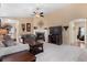 Cozy living room features neutral walls, vaulted ceiling, ceiling fan, fireplace, and plush seating at 6267 N Dunkirk Ct, Aurora, CO 80019