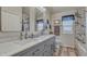 Bright bathroom featuring double sinks, marble counters, wood floors, and stylish decor at 16184 Gold Creek Dr, Monument, CO 80132