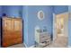 Stylish bedroom corner with wooden armoire, gray side table, and doorway to the bathroom at 16184 Gold Creek Dr, Monument, CO 80132
