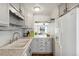 Bright kitchen featuring white cabinets, modern appliances, a view into the living room, and laminate countertops at 9044 W 63Rd Ave, Arvada, CO 80004