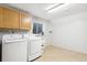 Bright laundry room with washer, dryer, cabinets, and utility sink at 9044 W 63Rd Ave, Arvada, CO 80004