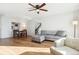 Bright living room featuring hardwood floors, modern furnishings, a ceiling fan, and an open view to the kitchen at 9044 W 63Rd Ave, Arvada, CO 80004