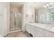 Bright bathroom featuring double sinks, a large mirror, and a glass-enclosed shower at 335 Josephine St # D, Denver, CO 80206