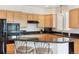 Well-lit kitchen boasts wooden cabinets, granite countertops, and a breakfast bar for casual dining at 335 Josephine St # D, Denver, CO 80206