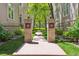 Inviting walkway with brick pillars leading to a serene path surrounded by mature trees at 335 Josephine St # D, Denver, CO 80206