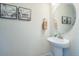 Powder room featuring a pedestal sink, framed art, and neutral wall color at 1842 Peak Prairie Ln, Monument, CO 80132