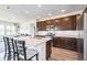 Beautiful kitchen featuring an island with seating, stainless steel appliances, and dark cabinetry at 1842 Peak Prairie Ln, Monument, CO 80132