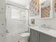 This full bathroom features retro wallpaper and a tub and shower combination with glass door at 4250 Wyandot St, Denver, CO 80211