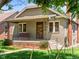 Inviting front exterior of a quaint home featuring a porch swing and landscaped garden at 4250 Wyandot St, Denver, CO 80211