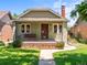 Charming bungalow-style home featuring a cozy front porch with swing and a well-maintained lawn at 4250 Wyandot St, Denver, CO 80211
