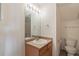 Small bathroom with a wood vanity, light fixtures, mirror, toilet, and shower at 2552 W 82Nd Ln # C, Westminster, CO 80031