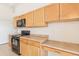 Bright kitchen features a black range and microwave, and light wood cabinets at 2552 W 82Nd Ln # C, Westminster, CO 80031