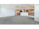 Bright, open living room flows into the kitchen with light wood cabinets and gray carpet at 2552 W 82Nd Ln # C, Westminster, CO 80031