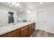 Spacious bathroom featuring double sinks, wood cabinets, and a walk-in shower at 1121 Acadia Cir, Erie, CO 80516